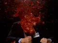 Un uomo in giacca e cravatta, vittima di un evento cruento, con sangue e detriti che esplodono in un'immagine tipica di un genere cinematografico con scene truculente.