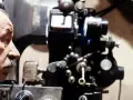 Un uomo e un bambino osservano affascinati una vecchia cinepresa, un'immagine che evoca le magiche tecniche cinematografiche.