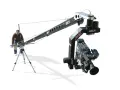 Un uomo manovra un braccio mobile per riprese cinematografiche, un vero crane per il cinema, con una telecamera professionale montata.
