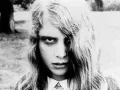 Primo piano di una bambina con sguardo inquietante, capelli lunghi e spettinati. Un'immagine iconica per chi ama i film trash da vedere.