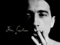 Primo piano di un volto illuminato da un lato, con la firma "Jean Cocteau" in corsivo. Un'immagine evocativa dei suoi film.