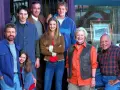 Cast di famiglie serie tv americane anni 2000, sorridono davanti a un negozio.
