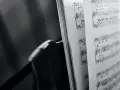 Spartito musicale aperto, con note e indicazioni di tempo, evoca le grandi colonne sonore che hanno segnato cinema e TV.