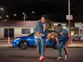 Due uomini in tuta sportiva portano una tartaruga, scena tipica dei film comici americani.