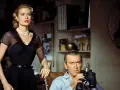 Grace Kelly e James Stewart in una scena di un film thriller suspense. Lui osserva con il binocolo, lei elegante in abito nero.