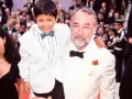 Un bambino sorridente, protagonista di "Nuovo Cinema Paradiso", abbracciato da un uomo con una rosa all'occhiello.
