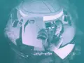 Inquadratura soggettiva: un astronauta in una navicella tiene in mano un disegno di sé stesso con casco.