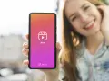 Una ragazza sorride mentre mostra il suo smartphone con l'icona di Reels, perfetta app per montare video e creare contenuti.
