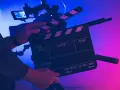 Un ciak pronto per segnare l'inizio di una ripresa. Serve a sincronizzare audio e video, un gesto iconico del cinema.