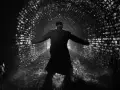 Uomo in un tunnel di mattoni illuminato, con le braccia aperte, come in un momento di rivelazione o un inaspettato plot twist.