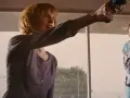 Donna e uomo puntano pistole, in una scena che ricorda un cliffhanger traduzione.