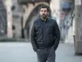 Edoardo Leo, con la sua aria pensierosa, cammina in un vicolo urbano, ricordando forse i suoi ruoli ne I Cesaroni.