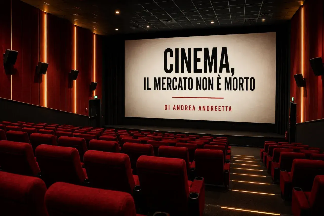Sala cinematografica vuota con schermo che recita "CINEMA, IL MERCATO NON È MORTO". Un'immagine che riflette la crisi del cinema, ma con un messaggio di speranza.