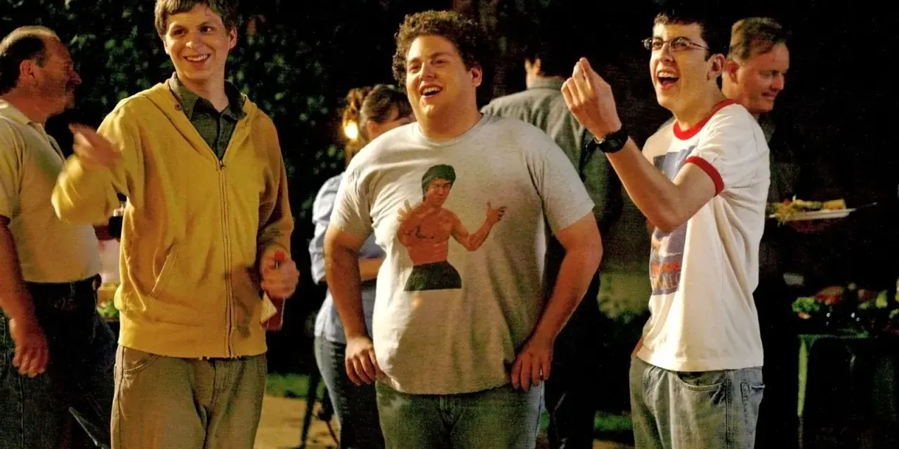 Tre amici ridono a una festa, un'iconica scena da commedie comiche.