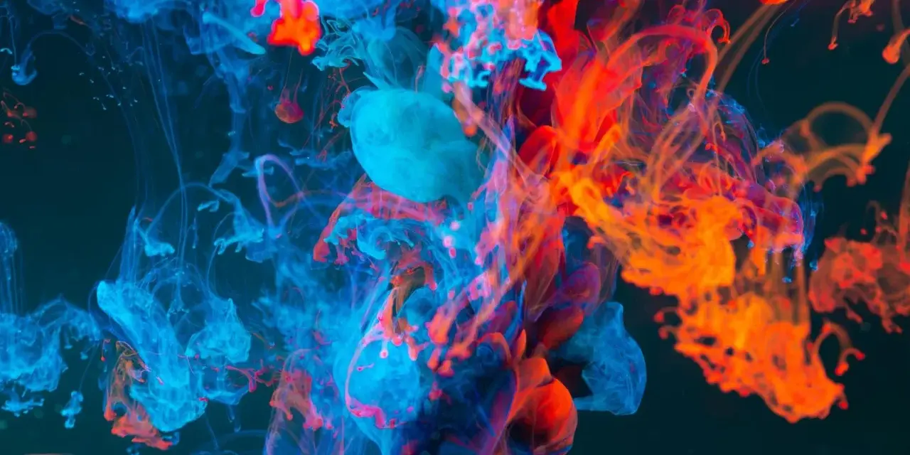 Nuvole di inchiostro blu e arancione si fondono in un vortice dinamico, evocando la potenza del colore nel cinema.