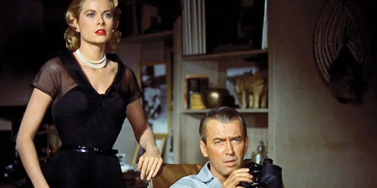 Grace Kelly e James Stewart in una scena di un film thriller suspense. Lui osserva con il binocolo, lei elegante in abito nero.