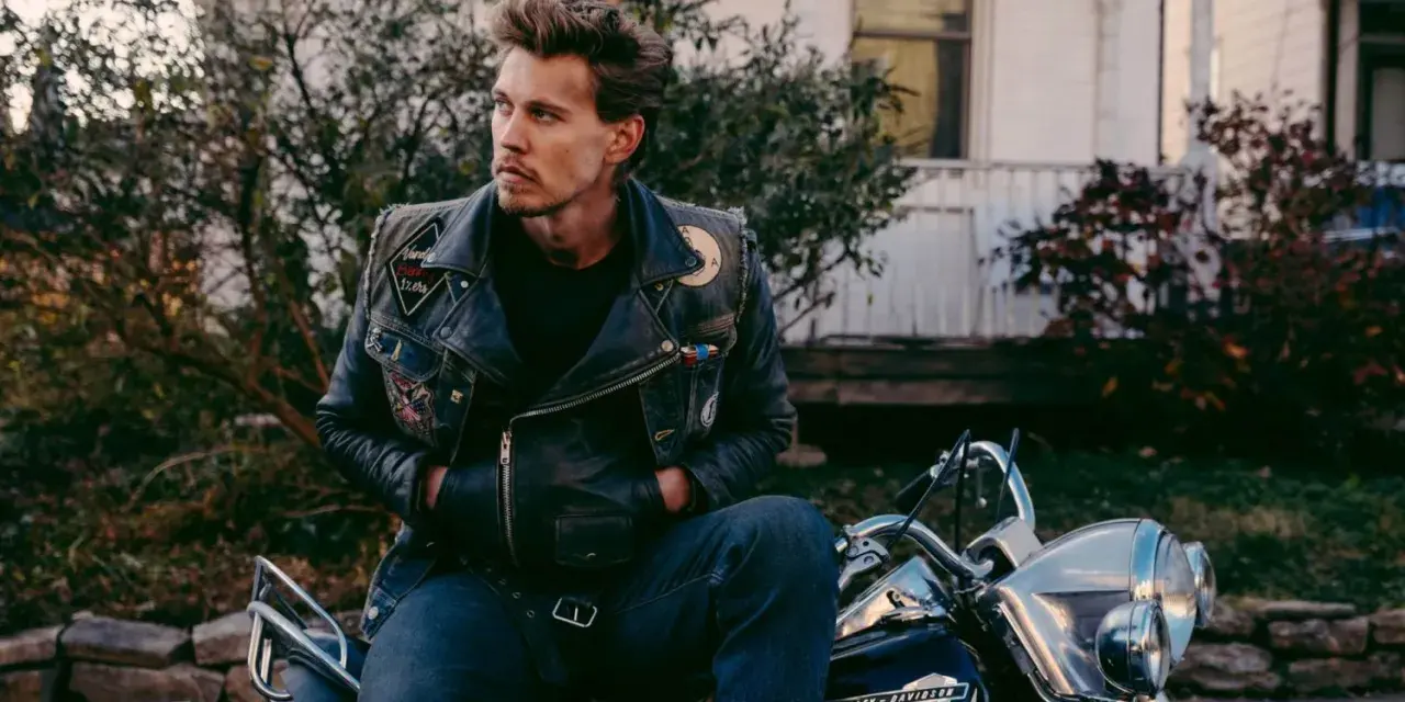 Austin North, protagonista di film e programmi TV, con giacca di pelle e moto.