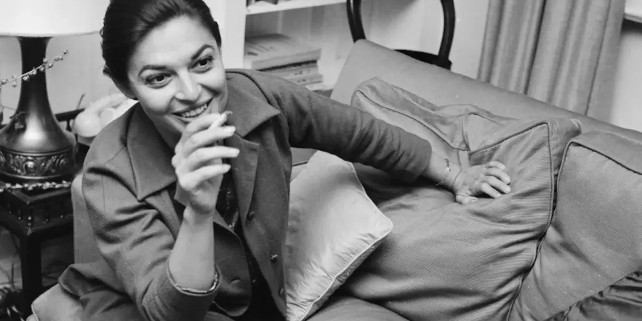 Anne Bancroft sorride con una sigaretta in mano, un'immagine che evoca la sua vivacità, prima che la causa morte la portasse via.