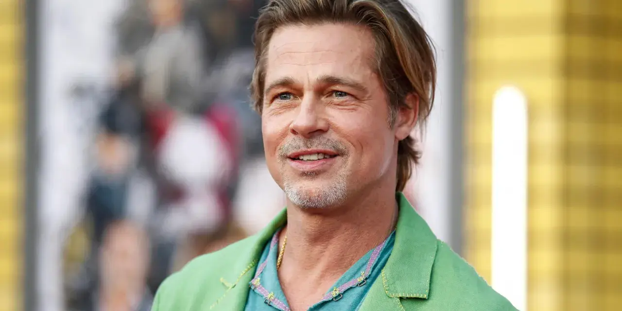 Brad Pitt, attore famoso, sorride con un completo verde acceso.