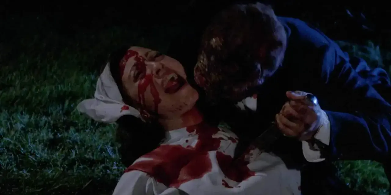 Una vittima urlante, coperta di sangue, viene attaccata da una figura grottesca con un coltello. Un'immagine raccapricciante che evoca un **horror cult**.