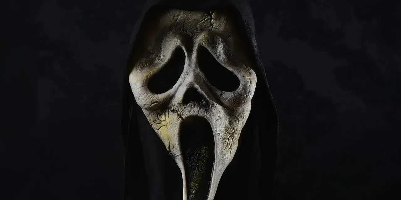 Maschera iconica di Ghostface, simbolo di horror paurosi, con cappuccio nero e sfondo scuro.