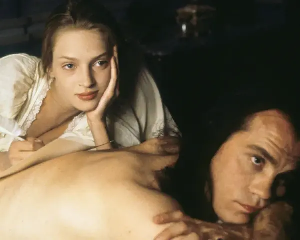Coppia in un momento intimo, evocativo di scene da film erotici. Lei scrive con una penna d'oca, lui la guarda intensamente.