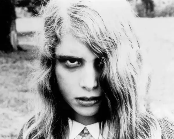 Primo piano di una bambina con sguardo inquietante, capelli lunghi e spettinati. Un'immagine iconica per chi ama i film trash da vedere.