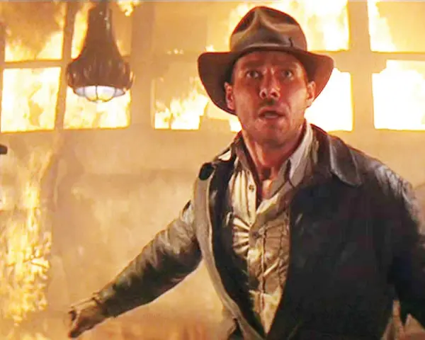 Indiana Jones in un edificio in fiamme, un momento iconico di film azione e avventura.
