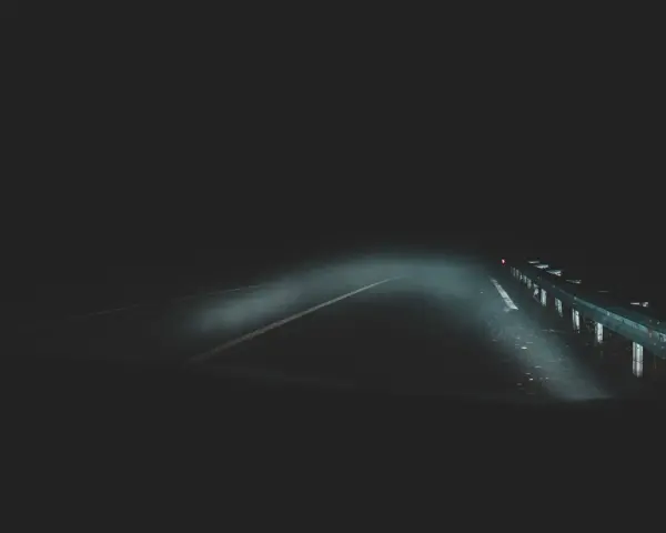 Strada buia e nebbiosa, un'atmosfera che evoca la differenza tra giallo e thriller. I fari illuminano un percorso incerto.