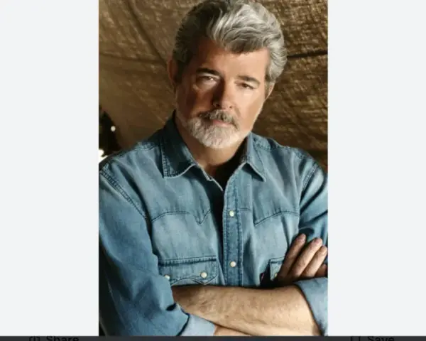 George Lucas, uno dei registi importanti, con barba grigia e camicia di jeans, braccia conserte.