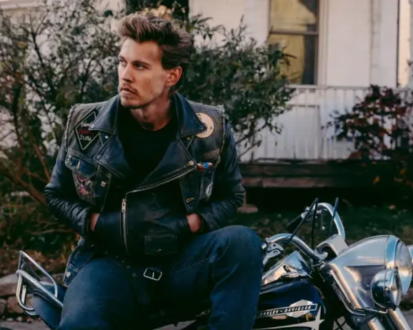 Austin North, protagonista di film e programmi TV, con giacca di pelle e moto.