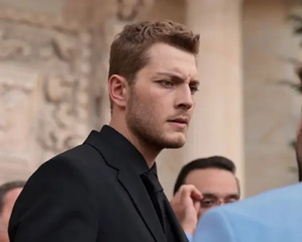 Francesco Montanari, con un abito scuro, interpreta un membro della squadra antimafia, con uno sguardo intenso.
