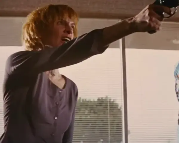 Donna e uomo puntano pistole, in una scena che ricorda un cliffhanger traduzione.