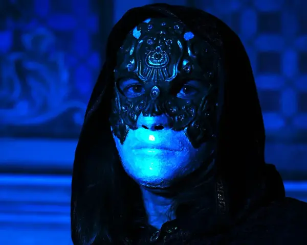 Volto mascherato con illuminazione blu intensa, un'immagine che evoca mistero e terrore, perfetta per i film horror più visti.