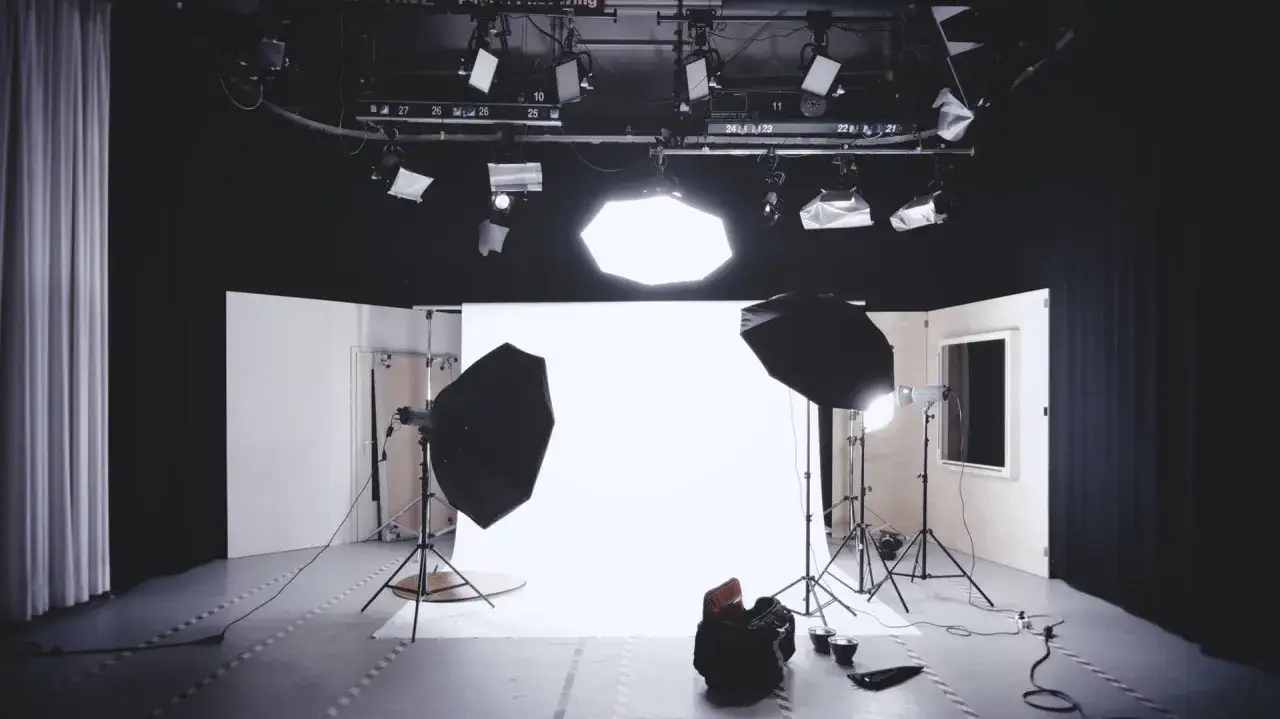 Un set vuoto pronto per le riprese, con luci da studio e fondale bianco. Le luci set cinematografico sono posizionate per creare l'atmosfera perfetta.