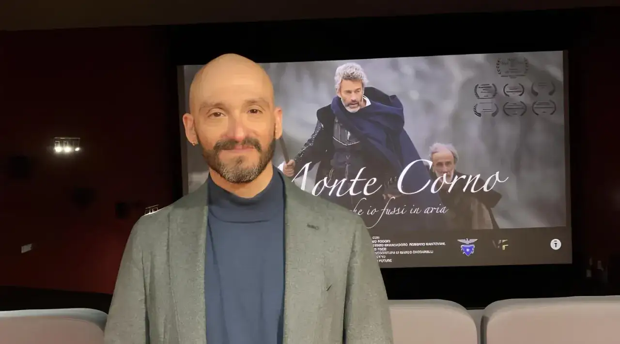 Emiliano Dante sorride davanti al poster del film 