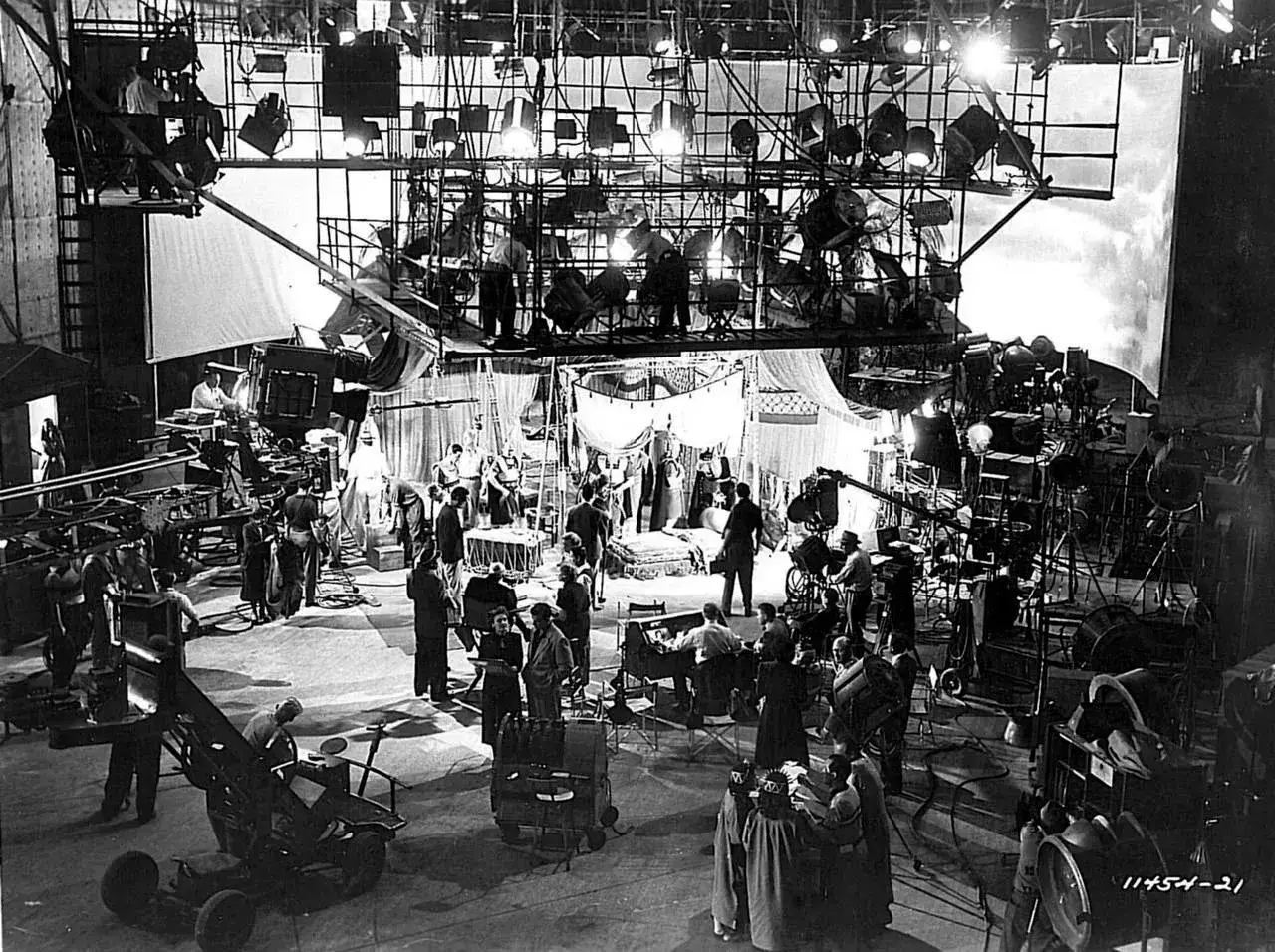 Un set cinematografico affollato, con troupe e attori, testimonia la frenetica attività dell'industria cinematografica americana.