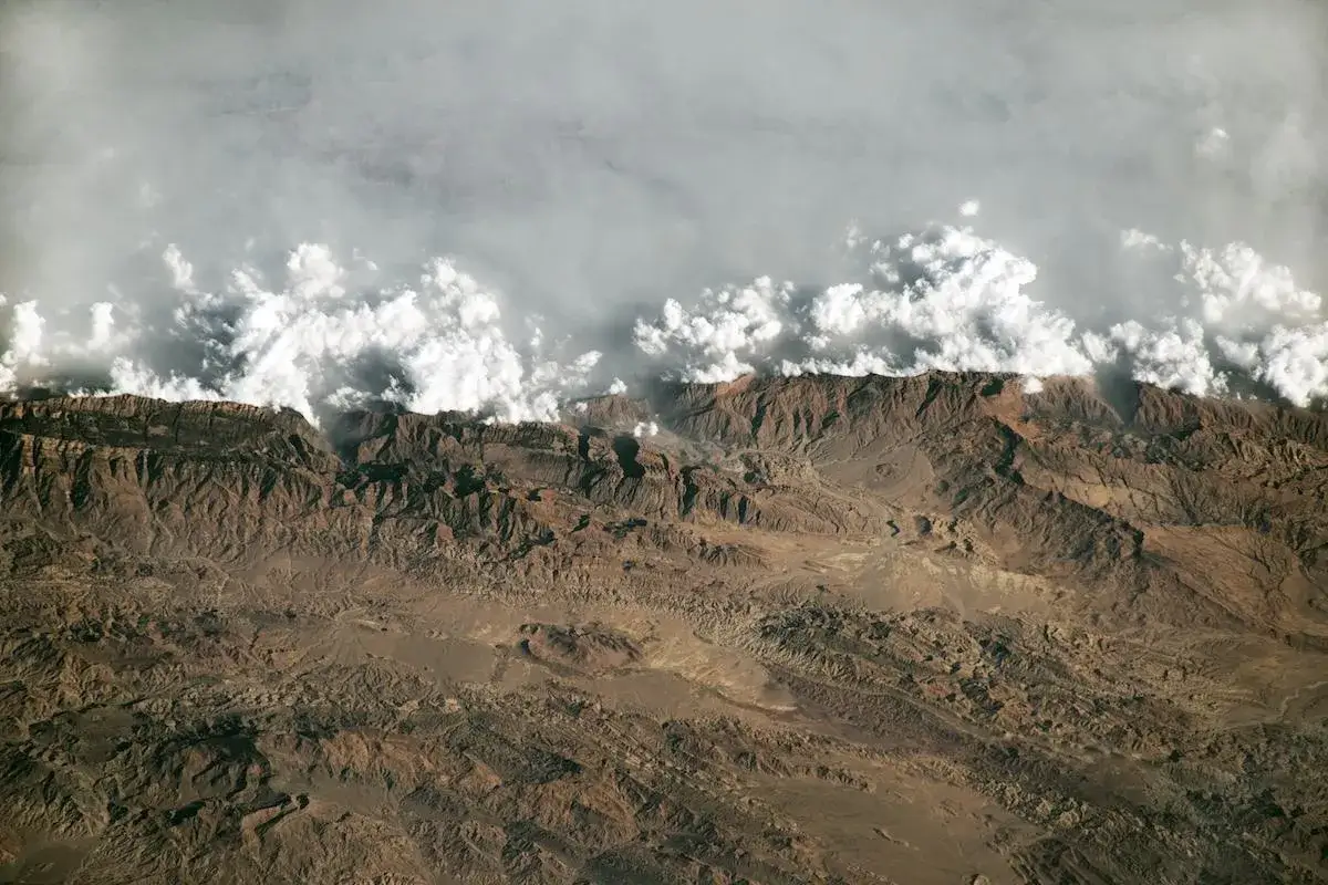 Vaste montagne brulle, coperte da nuvole soffici, sembrano un home documentario sulla Terra vista dall'alto.