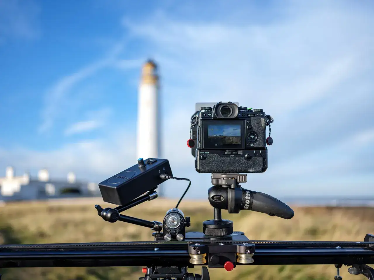Attrezzatura per time lapse con faro sfocato sullo sfondo. Il significato di time lapse &egrave; catturare il tempo che scorre.
