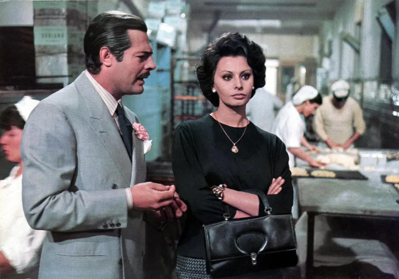 Marcello Mastroianni e Sophia Loren, icone delle commedie all'italiana, in una scena che evoca sapori e storie del cinema.
