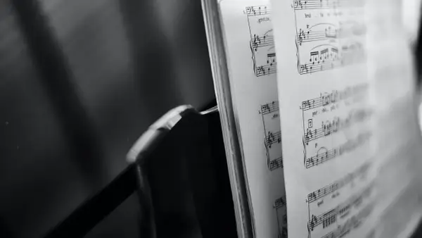 Spartito musicale aperto, con note e indicazioni di tempo, evoca le grandi colonne sonore che hanno segnato cinema e TV.
