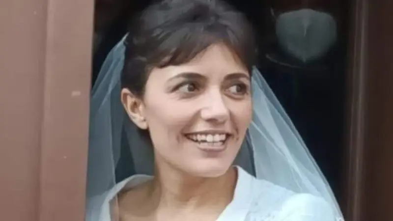 La sposa cast, con un velo leggero, sorride con gioia, pronta per il suo grande giorno.